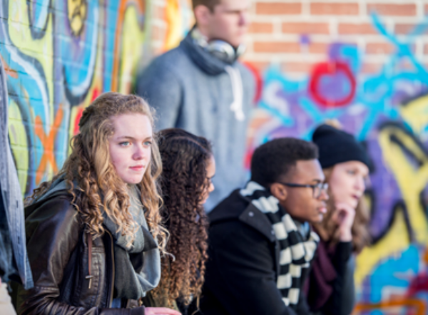 Groep jongeren voor muur met graffiti