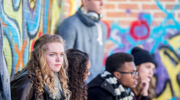 Groep jongeren voor muur met graffiti