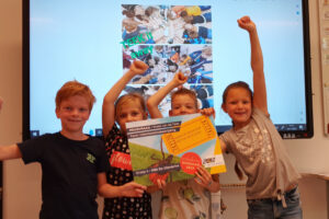 Leerlingen uit groep 4 van OBS De Uilenbrink juichen na ontvangst vanwaardecheck bioscoop bezoek.