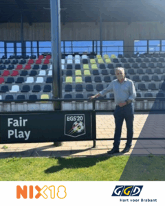 Foto van Edwin op een voetbalveld, met daaronder de logo's van Nix18 en GGD Hart voor Brabant